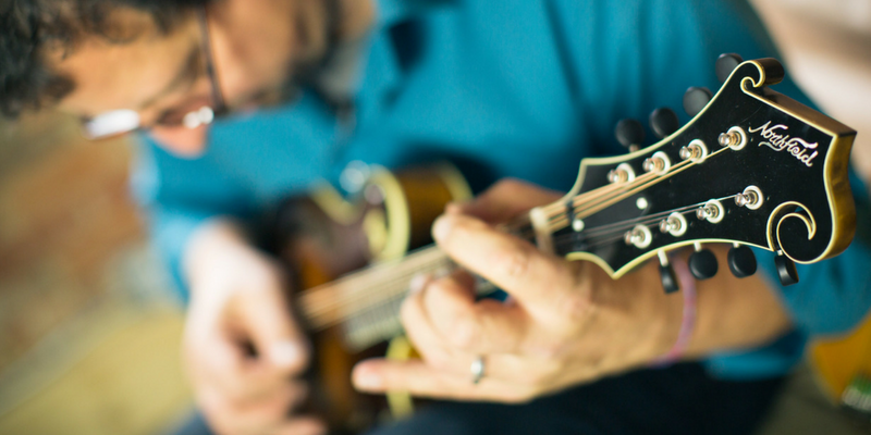 Mike Marshall Holding a Mandolin and Playing Mandolin Chords