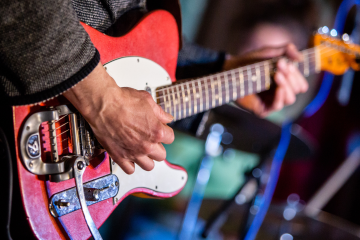 guitarist playing red and white guitar
