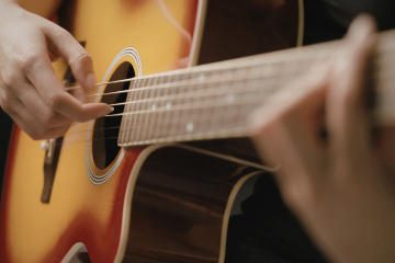 person playing an acoustic guitar
