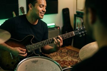 Close up of a guitar player playing a boogie shuffle and locking in with a drummer