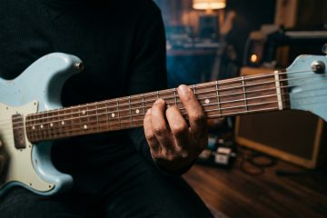 Close-up of a guitarist's fretting hand playing a boogie shuffle chord on an electric guitar