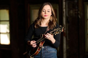 Sierra Hull playing mandolin in a rustic setting