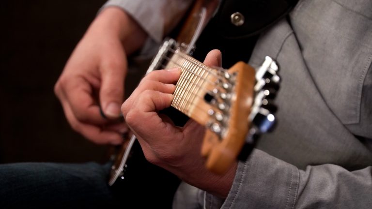 close up photo shot down the neck of a telecaster with Dave Isaacs playing seventh chords