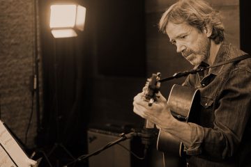 Tyler Grant teaches flatpicking in the studio, demonstrating how to learn a song