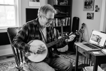 black and white photo of a man in his 60s improvising on banjo playing in a new key