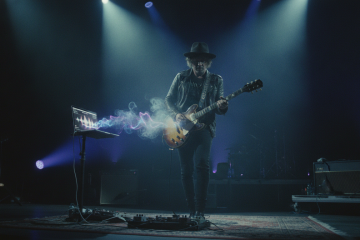 Music, meaning & AI: A guitarists performing live on stage with a laptop AI companion