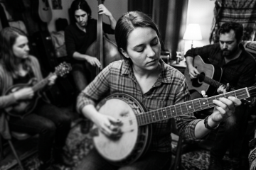 a young female in a jam session demonstrating how to start improvising on banjo
