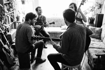 A small jam circle with the guitar player power strumming chords